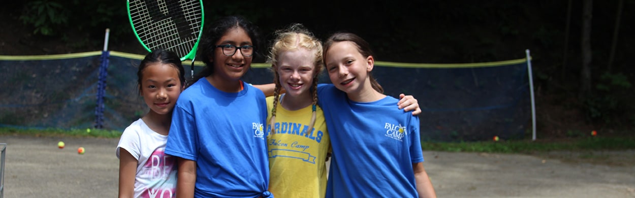 Campers playing tennis at summer camp