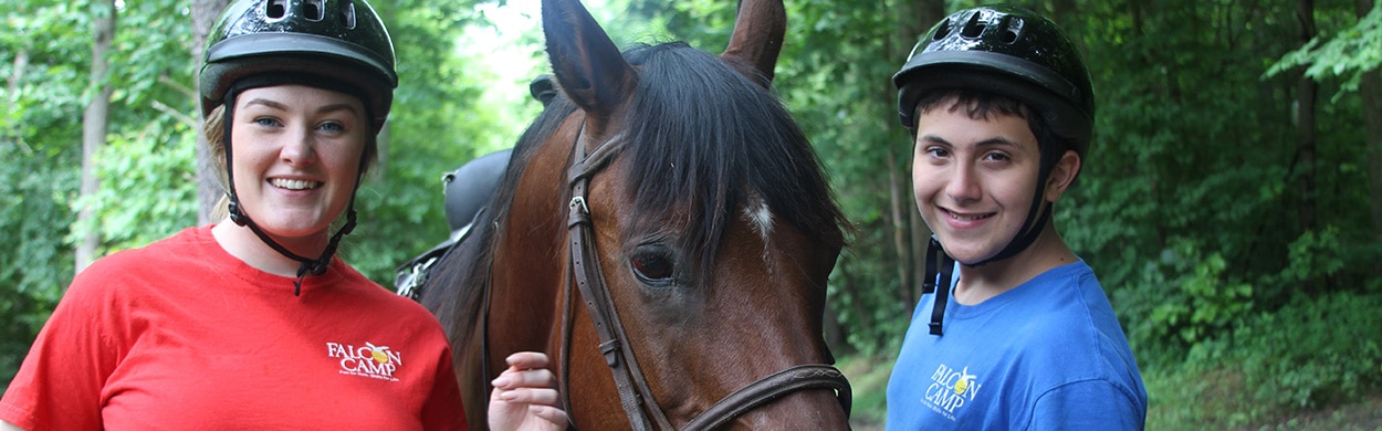 Camp instructor with camper and horse