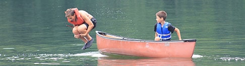 Boys in canoe on the lake at summer camp