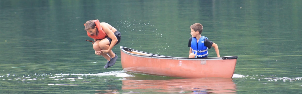 Campers enjoying waterfront activities like canoeing at Falcon Camp
